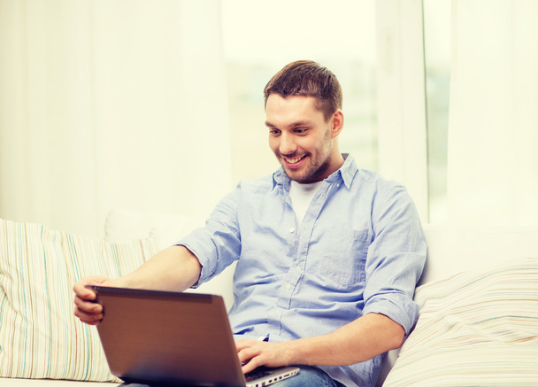 smiling man working with laptop at home - Fotó, kép