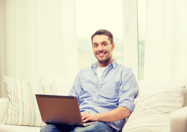 smiling man working with laptop at home - Valokuva, kuva