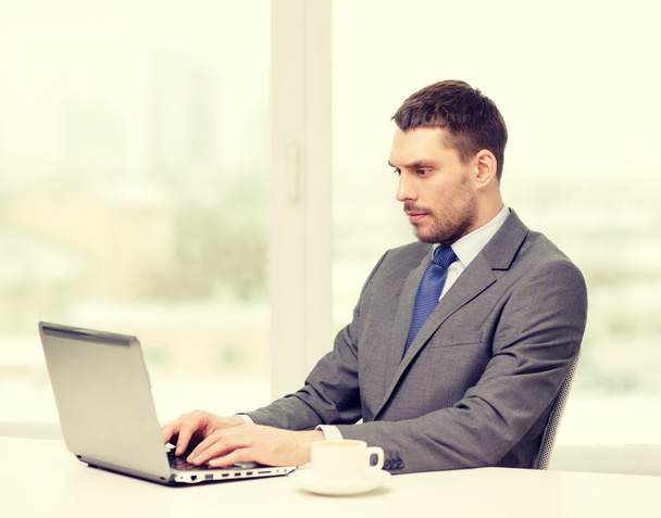 busy businessman with laptop and coffee - Fotografie, Obrázek