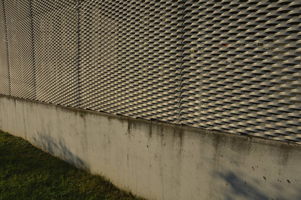 Stahlverkleidung eines Gebäudes mit einer Streckmetallgitterstruktur. verzinkte graue Netze schützen das Industriegebäude. Blauer Himmel im Kontrast zu silbernem Hintergrund, Treppe, Labor, Wissenschaft - Foto, Bild