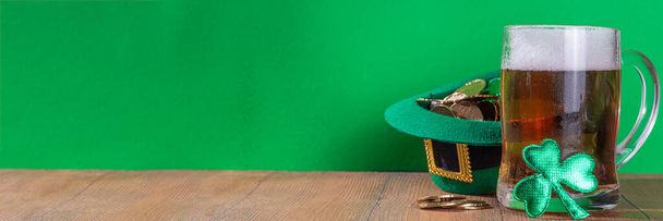 Okulary piwne w kapeluszu krasnoludka, liście koniczyny, tradycyjne dekoracje na Dzień św. Patryka, na zielonym tle. Karta okolicznościowa St. Patrick 's Day Ireland, tło zaproszenia - Zdjęcie, obraz
