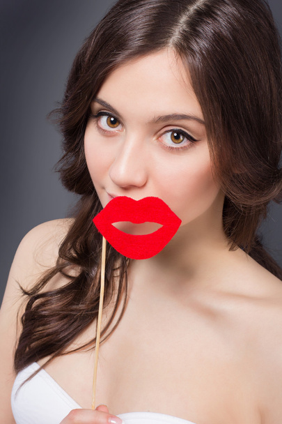 Beauty happy girl with Valentine lips. Smiling surprised model girl takes lips shaped red. - Foto, Bild