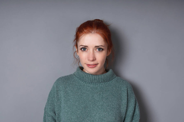 Mitte erwachsene Frau trägt Rollkragenpullover vor grauem Hintergrund mit Kopierraum - Foto, Bild