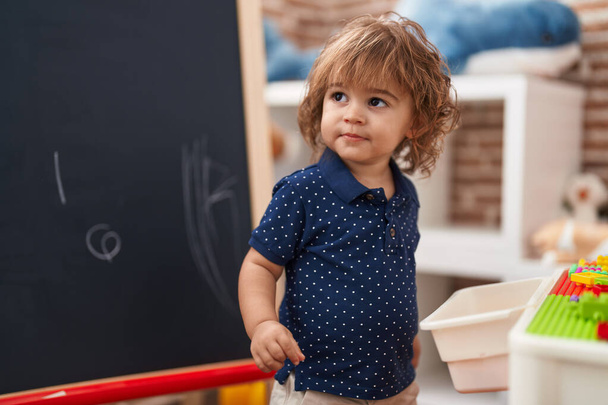 Entzückende hispanische Kleinkindstudentin zeichnet auf Schultafel im Kindergarten - Foto, Bild