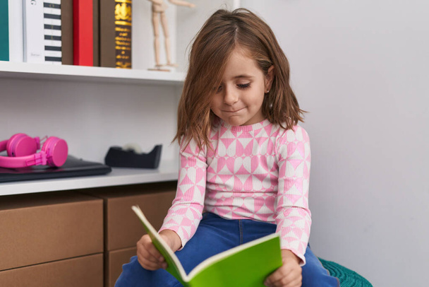 Αξιολάτρευτο ισπανόφωνη μαθήτρια χαμογελά αυτοπεποίθηση βιβλίο ανάγνωσης στο σχολείο της βιβλιοθήκης - Φωτογραφία, εικόνα