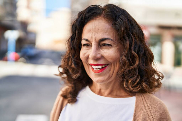 Mujer hispana de mediana edad sonriendo feliz al aire libre - Foto, Imagen