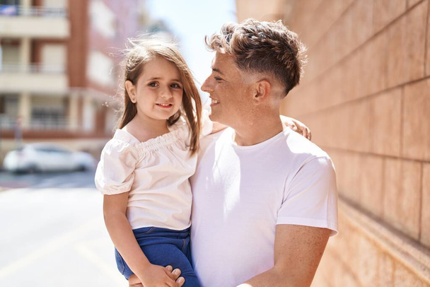 Padre e hija sonriendo confiados abrazándose en la calle - Foto, Imagen