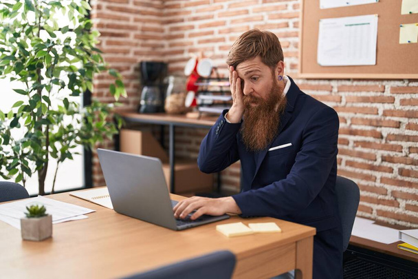 Young redhead man business worker using laptop working at office - Фото, изображение