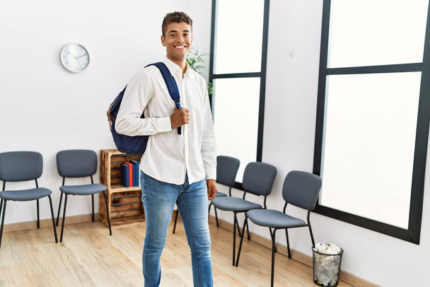 Junger hispanischer Mann wartet mit Studententasche im Wartezimmer - Foto, Bild
