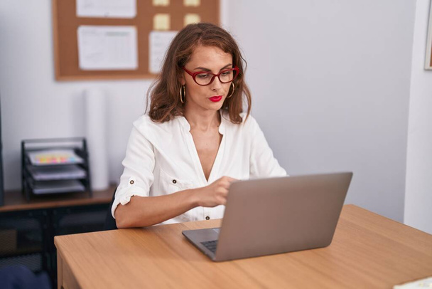 Young beautiful hispanic woman business worker using laptop working at office - Foto, imagen