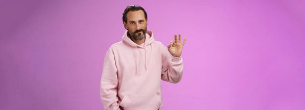 Confident good-looking lucky old macho guy bearded grey hair in stylish pink hoodie hold hand pocket show okay ok approval gesture smirking delighted agree daughter choice, posing supportive. - Photo, Image