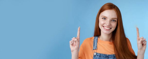 Waist-up charismatic good-looking european redhead woman smiling sincere gladly showing way pointing up index fingers happy help recommend cool advertisement spot, blue background. - Photo, Image