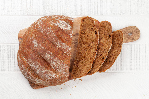 Gesneden zelfgemaakt brood op houten tafel. Vlakke plaat - Foto, afbeelding
