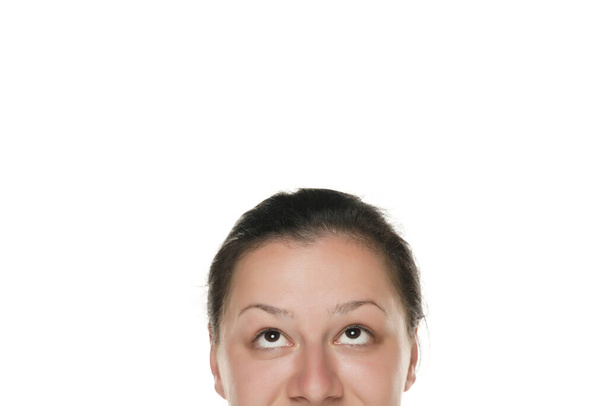 Halbporträt einer jungen pummeligen Frau, die nach oben blickt. - Foto, Bild