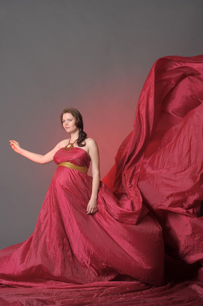 Pregnant woman in red flying dress - Fotoğraf, Görsel