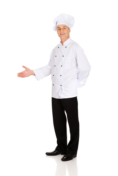 Happy mature chef with welcome gesture - Zdjęcie, obraz