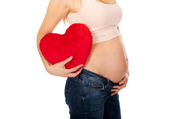 Pregnant woman with a heart pillow - 写真・画像