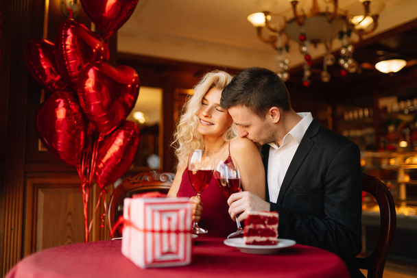 Young couple having a romantic dinner and toasting with glass of red wine. Valentine's Day concept. Relationship, surprise and love concept. - Фото, зображення