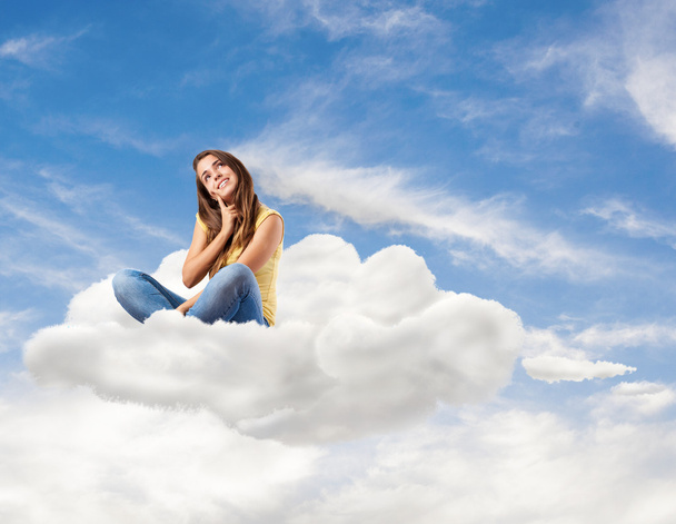 Fiatal, csinos nő ül a felhő - Fotó, kép