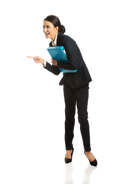 Businesswoman with binder pointing to the left - Фото, изображение