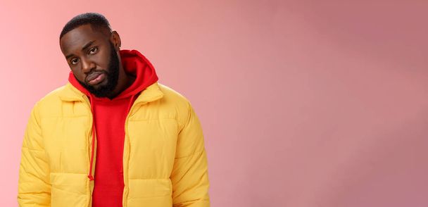 Unimpressed bored ignorant young african bearded man tilt head look scorn uninterest camera listen boring useless information, standing careless in yellow jacket red hoodie, indifferent. - Photo, Image