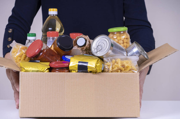 Žena dobrovolník ruce drží jídlo dárcovské krabice s potravinami produkty. Dary pro charitu, potravinovou banku. - Fotografie, Obrázek