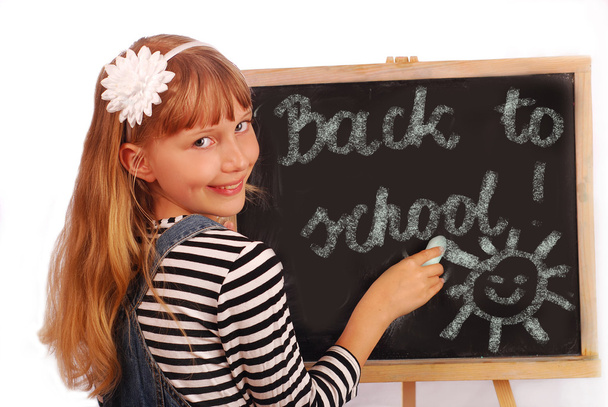 Schoolgirl writing on chalkboard - Zdjęcie, obraz