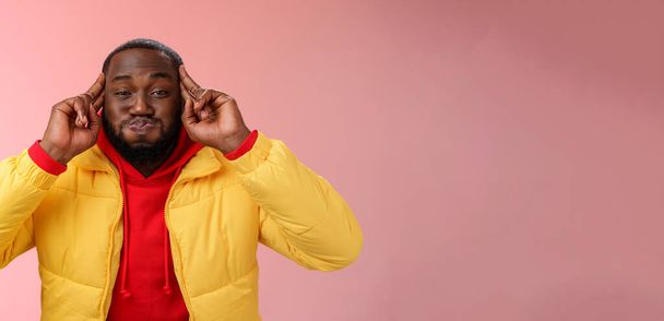 Észbontó információ. Portré játékos karizmatikus gondtalan afrikai szakállas fiatal 25-ös férfi duzzog tartsa lélegzetét gyerekes, amelynek szórakoztató eljáró éretlen vicces grimasz, álló rózsaszín háttér. - Fotó, kép