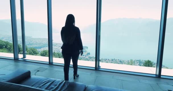 African businesswoman in modern office looking at window with breathtaking view - Footage, Video