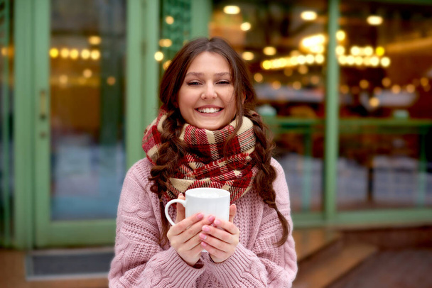 séta kávé utcában dekoráció Xmas téli ünnepek város. nő kockás sál inni forró kávé mályvacukor. - Fotó, kép