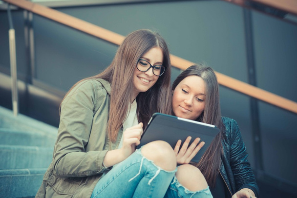 dos chicas jóvenes usando tableta
 - Foto, Imagen
