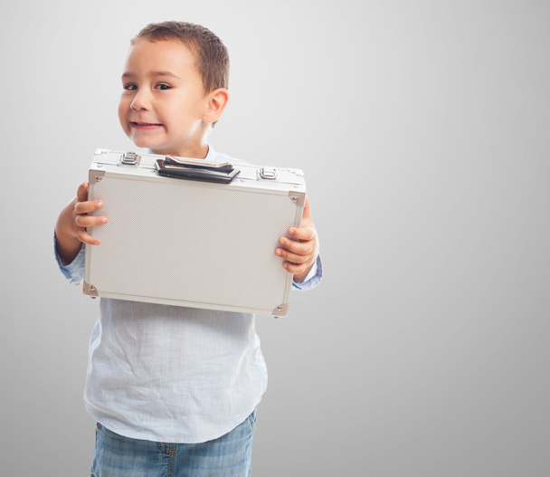 Little boy holding heavy briefcase - Foto, afbeelding