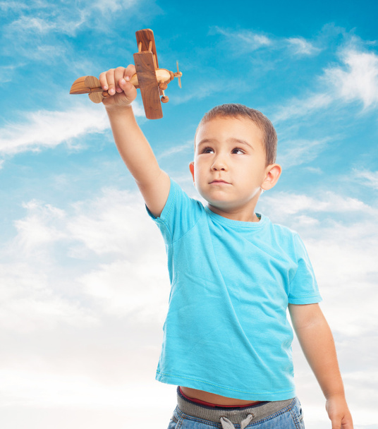 Küçük çocuk tahta uçakla oynuyor. - Fotoğraf, Görsel