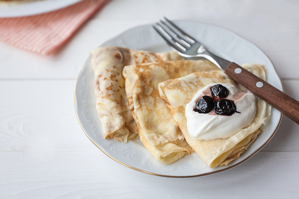 Ontbijt met pannenkoeken, jam, honing en melk - Foto, afbeelding