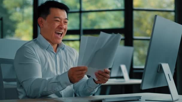 Emocional feliz asiático homem empresário escriturário especialista trabalhador chinês coreano masculino fazendo papelada alegrar negócio bem sucedido atirar papéis para cima no escritório lugar obter rentável contrato documento - Filmagem, Vídeo