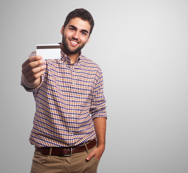 Young man showing credit card - Valokuva, kuva