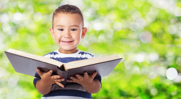Lindo niño sosteniendo libro grande
 - Foto, Imagen