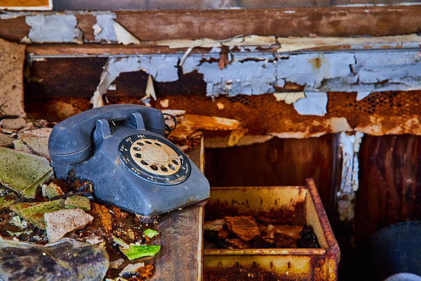 放棄された机の上のヴィンテージロータリー電話の画像劣化した壁で詳細に - 写真・画像