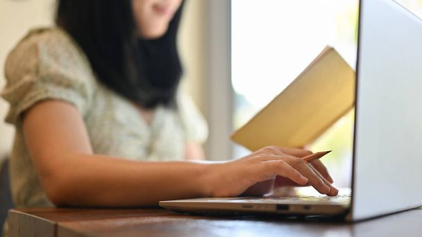 oříznutý obrázek, Mladá asijská žena pomocí notebooku, pracuje na svém projektu v kanceláři. - Fotografie, Obrázek