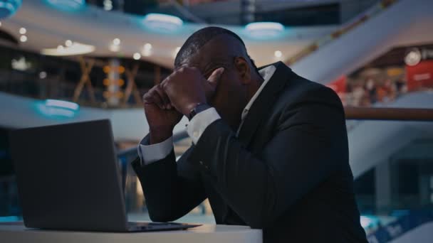 Empresário de meia-idade empresário Africano trabalhador com laptop triste chateado sentir dor de cabeça dor de cabeça problema com o trabalho do computador homem adulto tem problema de ansiedade com aplicativo on-line acidente aplicativo más notícias - Filmagem, Vídeo