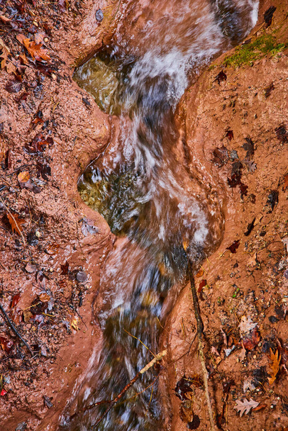 Afbeelding van River Creek in klei gesneden golvend patroon met bladeren van boven vallen - Foto, afbeelding