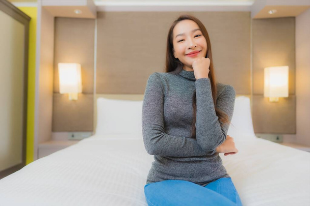 retrato hermosa joven asiática mujer relax sonrisa ocio en cama en dormitorio interior - Foto, Imagen