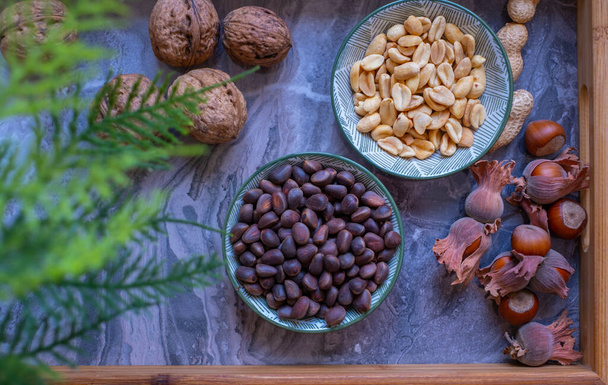 Erilaisia pähkinöitä kulhoja ylhäältä katsottuna. Saksanpähkinät, hasselpähkinä, maapähkinä ja pinjansiemenet, sekoita valinta. Terveellinen kunto super ruoka - Valokuva, kuva