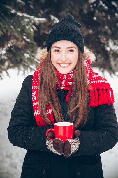 Girl drinking hot tea in the winter forest - Foto, afbeelding