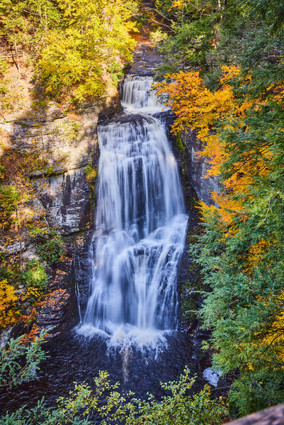 Kuva pystysuora lähellä suuri vesiputous ylhäältä ympäröivät kalliot ja syksyllä metsät - Valokuva, kuva