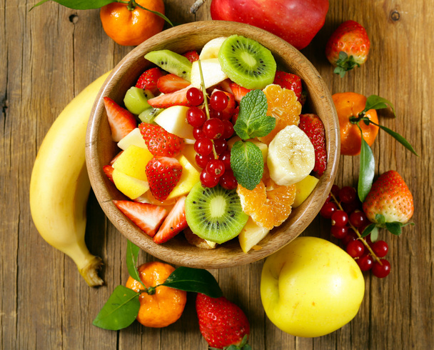 Салат из свежих органических фруктов (киви, клубника, банан, смородина, яблоко
) - Фото, изображение