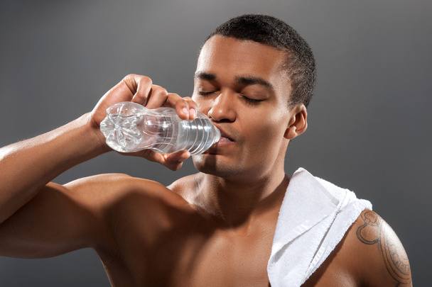Young Africana sportsman drinking water after workout - Фото, зображення