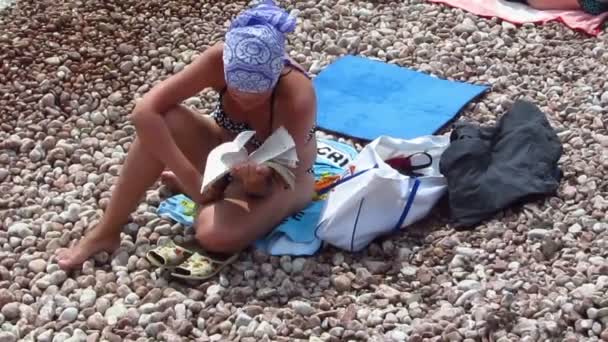 Девушка читает книгу на пляже
 - Кадры, видео