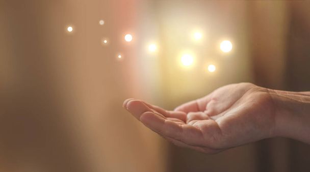 open palm hand holding glowing sparkles, flying fireflies, magic dust - Photo, image
