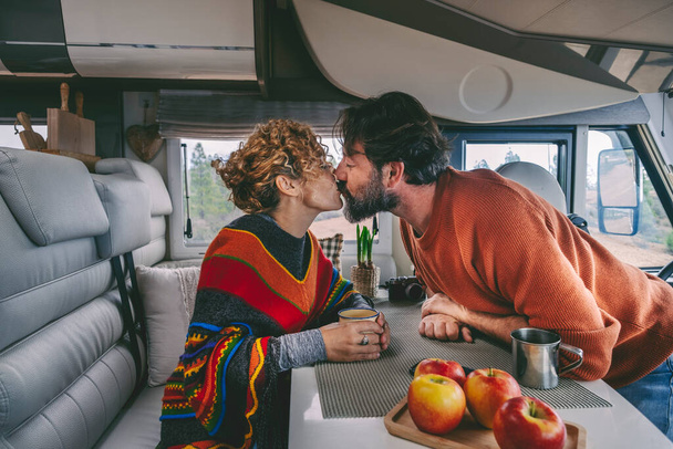 Seyahat macerası sırasında karavanda aşk ve öpüşme çifti. İlişkisi olan kadın ve erkekle romantik bir şekilde öpüşen hayat tarzı. İnsanlar tatilin ve yolculuğun tadını çıkarıyor - Fotoğraf, Görsel